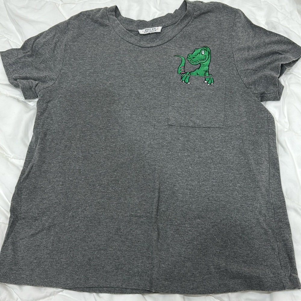 Dinasour peeking from pocket T-shirt